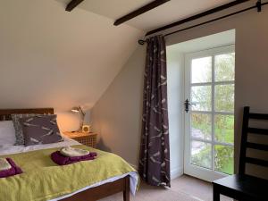 a bedroom with a bed and a large window at Charming cottage with loch and hill views nr Edinburgh in Cobbinshaw