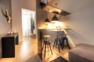 a kitchen with a counter and stools in a room at Urban Central Suites in Cagliari