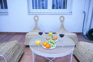 einen Tisch mit einer Schale Obst und zwei Gläsern Wein in der Unterkunft Stay U-nique Apartments Sant Eudald in Barcelona