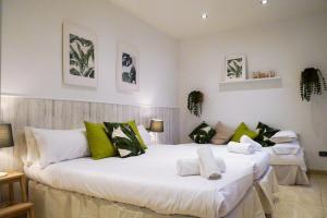 a bedroom with a large white bed with green pillows at Stay U-nique Apartments Sant Eudald in Barcelona