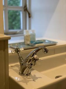 a kitchen sink with a faucet on top of it at Charming cottage with loch and hill views nr Edinburgh in Cobbinshaw