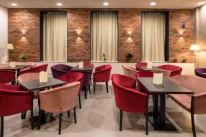 a dining room with tables and red chairs at Concorde Old Bucharest Hotel in Bucharest
