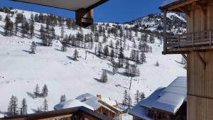 une vue d'une montagne enneigée depuis un chalet de ski dans l'établissement appart chalet hameau des rennes - luxe -pied des pistes, à Vars 2 autres photos