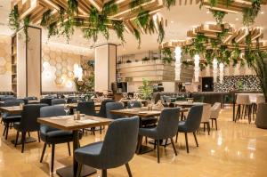 een restaurant met tafels, stoelen en planten bij Ilunion Valencia 4 in Valencia