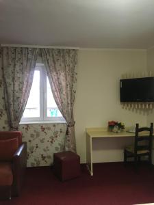 a room with a window with a desk and a television at Pension La Viorel Isaila in Sibiu