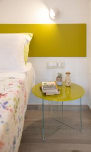 a bed room with a yellow table next to a bed at ARIA Design B&B Levanto in Levanto