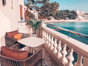 a patio area with chairs and a balcony overlooking the ocean at Splendid Hôtel in Bandol