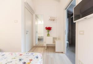 a white room with a bed and a vase of flowers at ARIA Design B&B Levanto in Levanto
