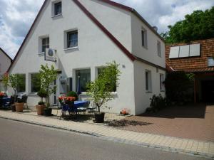 a white house with a table and chairs on a street at Gasthaus - Pension Am Buchberg in Mönchsdeggingen