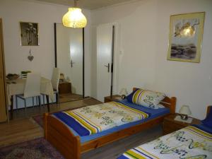 a bedroom with two beds and a dining table at Gasthaus - Pension Am Buchberg in Mönchsdeggingen