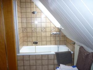a bathroom with a bath tub with a window at Gasthaus - Pension Am Buchberg in Mönchsdeggingen
