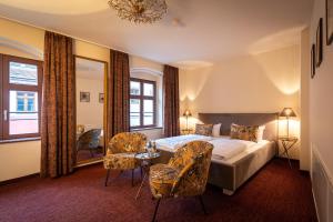 a bedroom with a bed and a table and chairs at Pension Donatus in Pirna