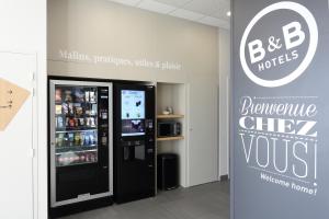 a store with a refrigerator and a sign next to it at B&B HOTEL Chaumont in Chaumont