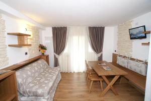 a living room with a table and a couch at Adler ApartHotel in Moena