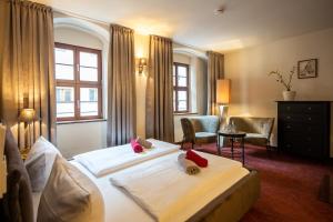 um quarto de hotel com duas camas e uma cadeira em Pension Donatus em Pirna