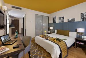 ein Hotelzimmer mit einem Bett und einem Schreibtisch mit einem Laptop in der Unterkunft Citadines City Centre Frankfurt in Frankfurt am Main