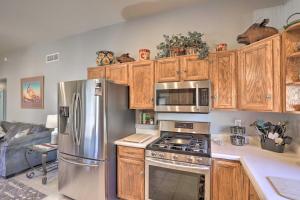a kitchen with stainless steel appliances and wooden cabinets at Desert Gem with Patio and Grill, Near Oracle St Park! in Oracle