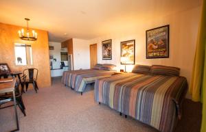 um quarto de hotel com duas camas e uma mesa em Raton Pass Motor Inn em Raton