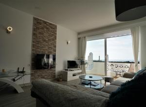 a living room with a couch and a large window at Vila Gaivota 3G in Ferragudo