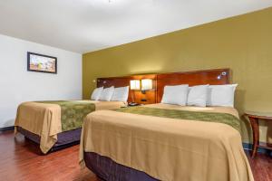 Postel nebo postele na pokoji v ubytování Rose City Inn & Suites