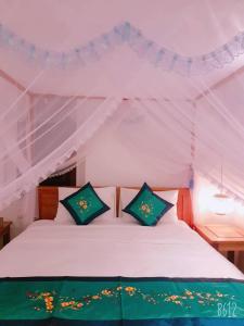 a bedroom with a white bed in a tent at Hoi An Sea Village Homestay in Hoi An