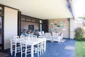 a dining room with a white table and white chairs at 2 Marichel Beachfront Condo in Ballito