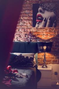 um quarto com uma parede de tijolos e uma cama com batom vermelho em APARTAMENT dLA DOROSŁYCH "PAPIERKI PO CUKIERKACH" em Lublin