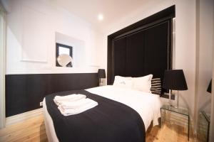 a bedroom with a black headboard and a white bed at Bliss Lisbon Apartments - Bairro Alto in Lisbon