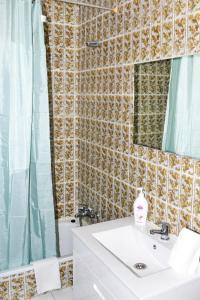 een badkamer met een wastafel, een spiegel en een toilet bij Ria Guest House in Alvor