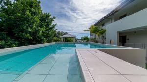 a swimming pool with a gazebo next to a house at Alpha 8 on Waterson - Airlie Beach in Airlie Beach