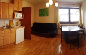 a kitchen with a table and a couch in a room at Apartments Iris in Liptovský Mikuláš