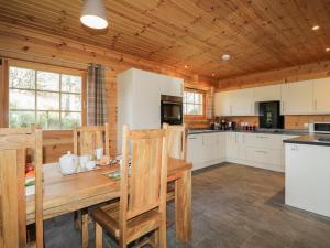 uma grande cozinha com uma mesa de madeira e cadeiras em Allt Lodge em Inverness
