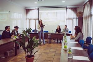 a woman standing in front of a presentation in a meeting room at Hotel Albaida Nature in Mazagón