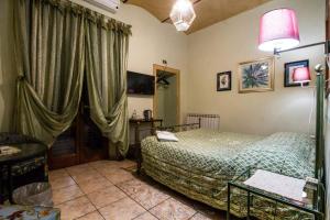 een slaapkamer met een bed en een raam met gordijnen bij B&B Cribò in San Giuliano Terme