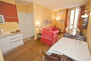 een keuken met een woonkamer met een bank en een tafel bij PROMENADE HOLIDAY - GRIMALDI CITY CENTER in Nice