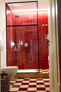 a bathroom with a red tiled shower with a toilet at Casa René - Charming apartments in Almada