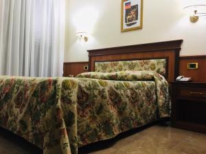 - un canapé dans une chambre d'hôtel avec une couverture dans l'établissement Hotel Malaga, à Avellino