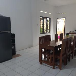 comedor con mesa, sillas y TV en Ndalem Diajeng, en Yogyakarta