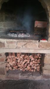 a brick oven with a pile of fire wood at Saffier river cottage Farmstay in Lady Grey