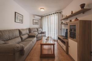 ein Wohnzimmer mit einem Sofa und einem Tisch in der Unterkunft Apartamento Roller - a pie de playa in Zahara de los Atunes
