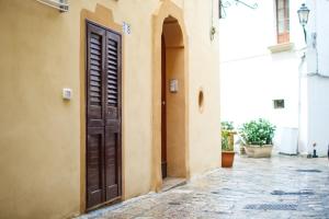 an alley with a brown door in a building at Dimora Garibaldi Rooms - center-Wi-fi in Gallipoli