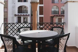 eine Terrasse mit einem Tisch und Stühlen auf dem Balkon in der Unterkunft Apartamento Roller - a pie de playa in Zahara de los Atunes