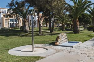 einen Baum in einem Park mit Palmen und Häusern in der Unterkunft Apartamento Roller - a pie de playa in Zahara de los Atunes