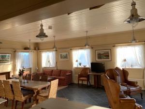 a living room with a couch and a table and chairs at Moldegaard Riding Lodge in Moldegard