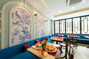 a restaurant with blue walls and tables with food at Sino Siam Hotel in Klong Muang Beach