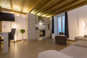a living room with a table and a kitchen at Le Suites Del Duomo House in Catania