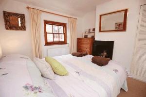 een slaapkamer met een groot wit bed en een open haard bij Cottages-Whitby in Whitby