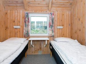 2 Betten in einem Holzzimmer mit Fenster in der Unterkunft Four-Bedroom Holiday home in Vejers Strand 9 in Vejers Strand