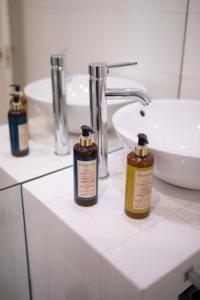 a bathroom with three bottles of soap and a sink at Bliss Lisbon Apartments - Bairro Alto in Lisbon