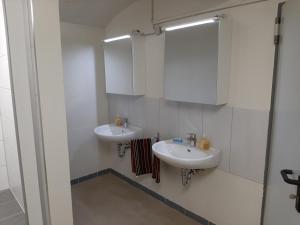 a bathroom with two sinks and a mirror at Monteurwohnung Zentrum in Zerbst